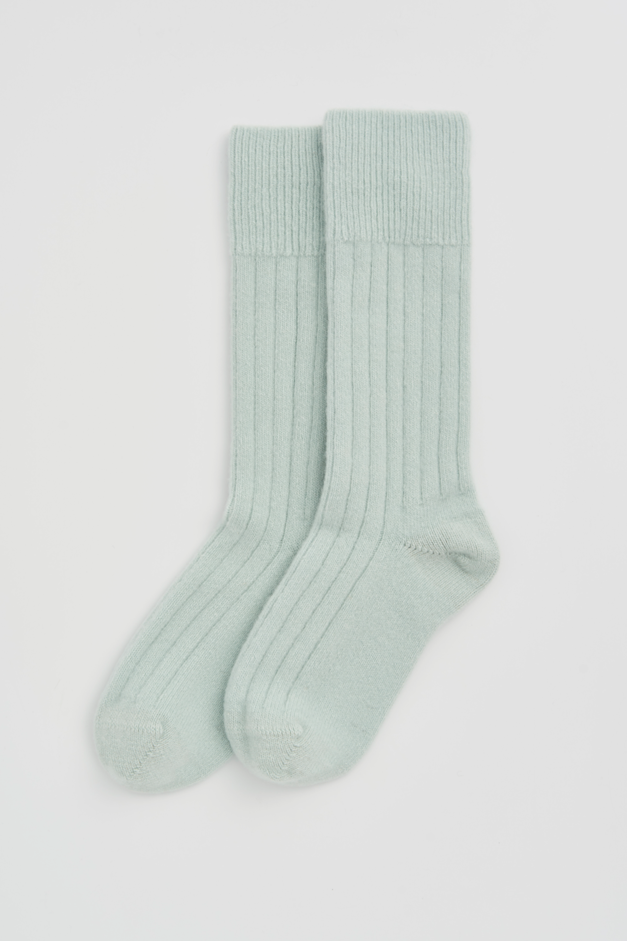 Pair of light green Merino socks on a white background