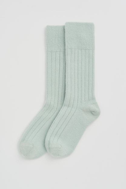 Pair of light green Merino socks on a white background